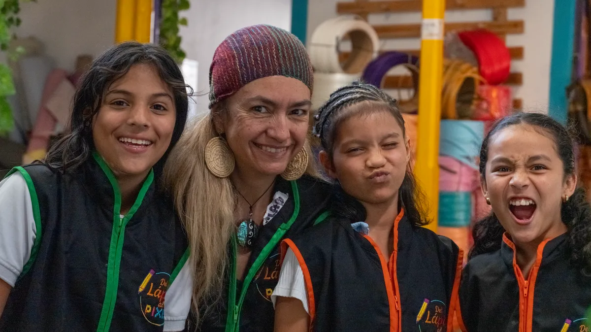 Cuatro niñas del programa junto a su mentora, con los chalecos de Del Lápiz al Píxel