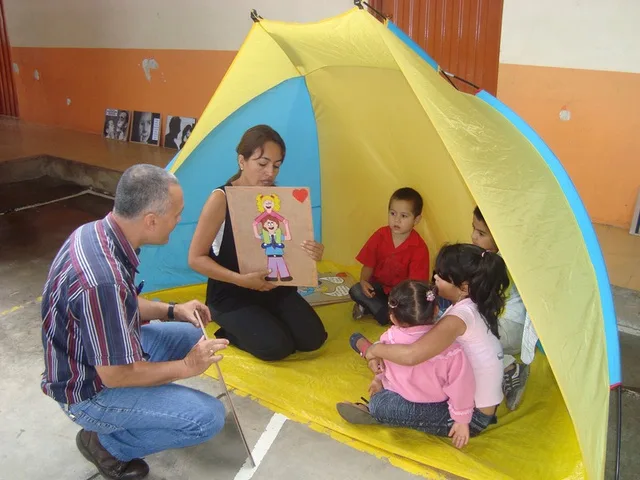 Taller con niños pequeños dentro de una carpa en el patio de una escuela