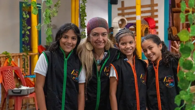 Cuatro niñas del programa sonriendo junto a una mentora