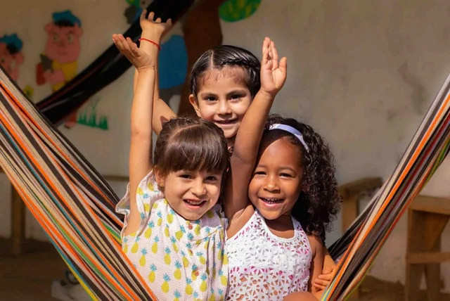 Tres niñas jugando en una hamaca durante una jornada del programa